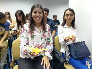 Cristina Henriques, uma das fundadoras do Núcleo da Madeira, e Ana Andrade, Coordenadora Operacional, sentadas na plateia enquanto seguram, cada uma, um dos exemplares produzidos pela Sala de Projetos de Automação e Robótica da ESFF