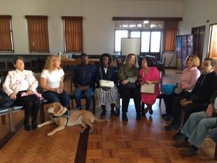 Grupo de Beneficiários sentados, em cadeiras, durante o encontro.