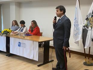 Rodrigo Santos durante o seu discurso. Ao fundo, na mesa, vê-se os elementos da MAR, Rosa Esteves, Secretária, e Helena Fonseca, Presidente, e a colaboradora Sandra Pereira. 